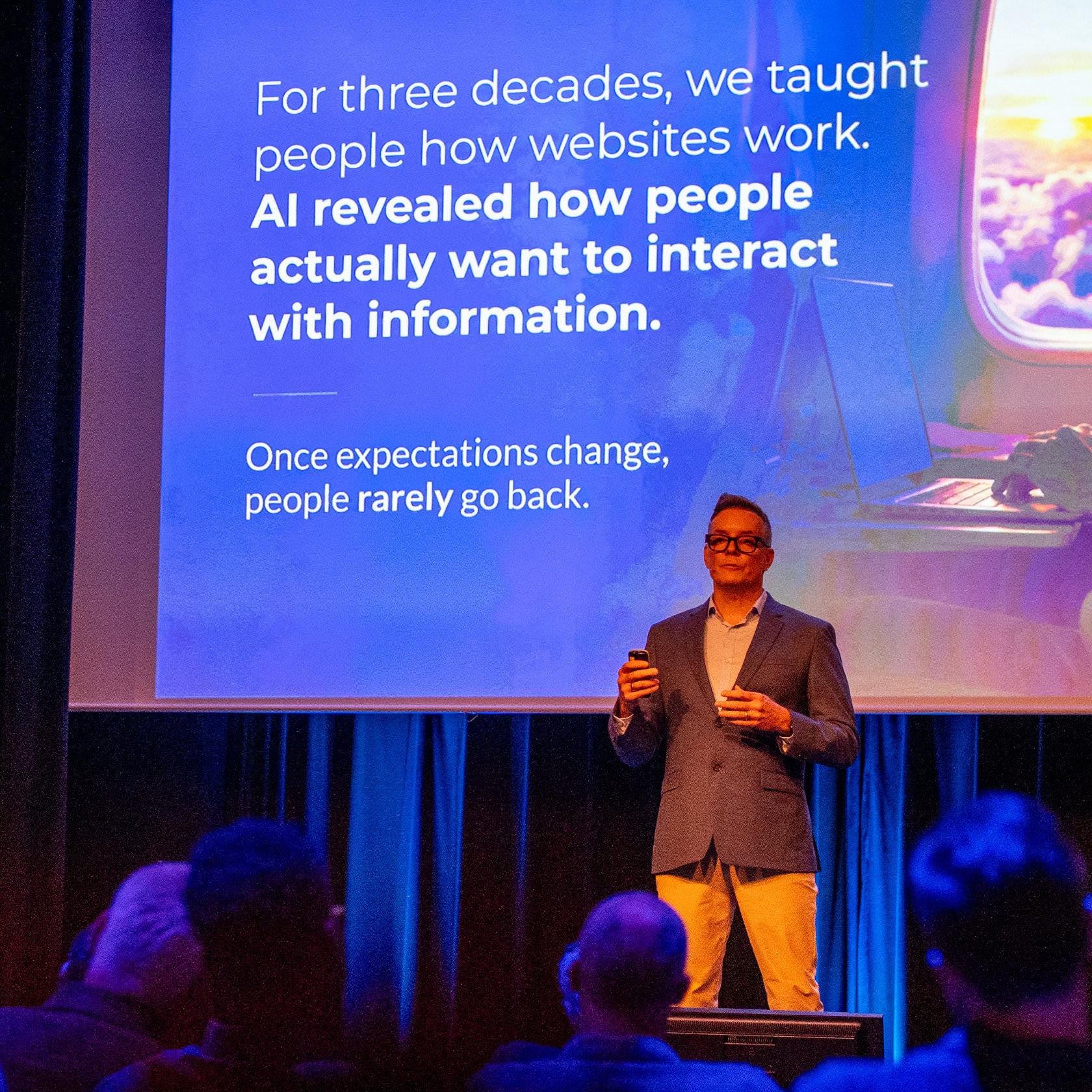 A presenter in front of a slide about how AI changed expectations of interacting with information