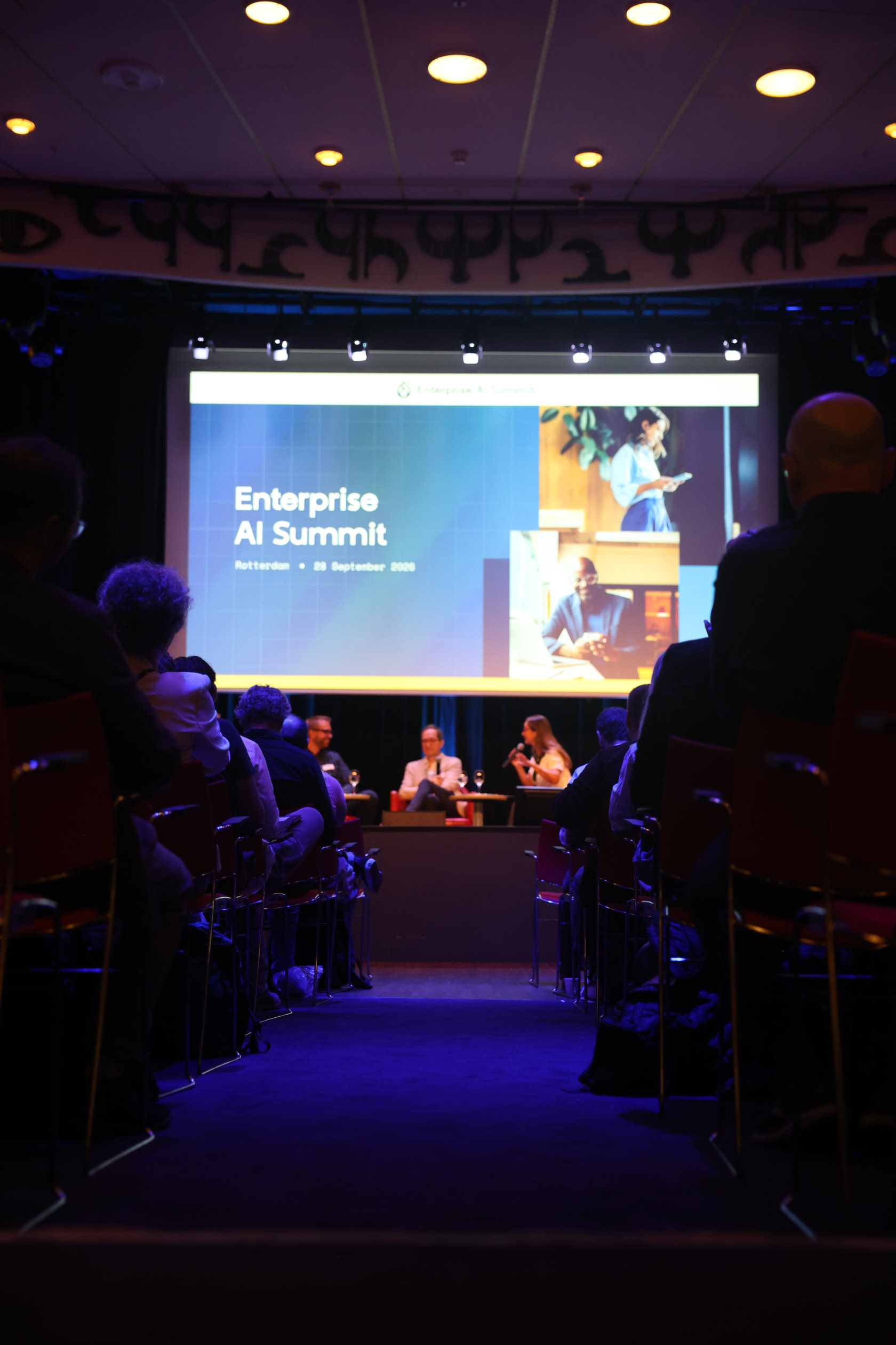 The audience facing a panel on stage under the Enterprise AI Summit title screen